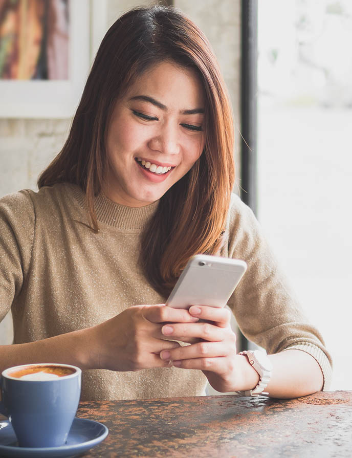 woman smiling at her cell phone