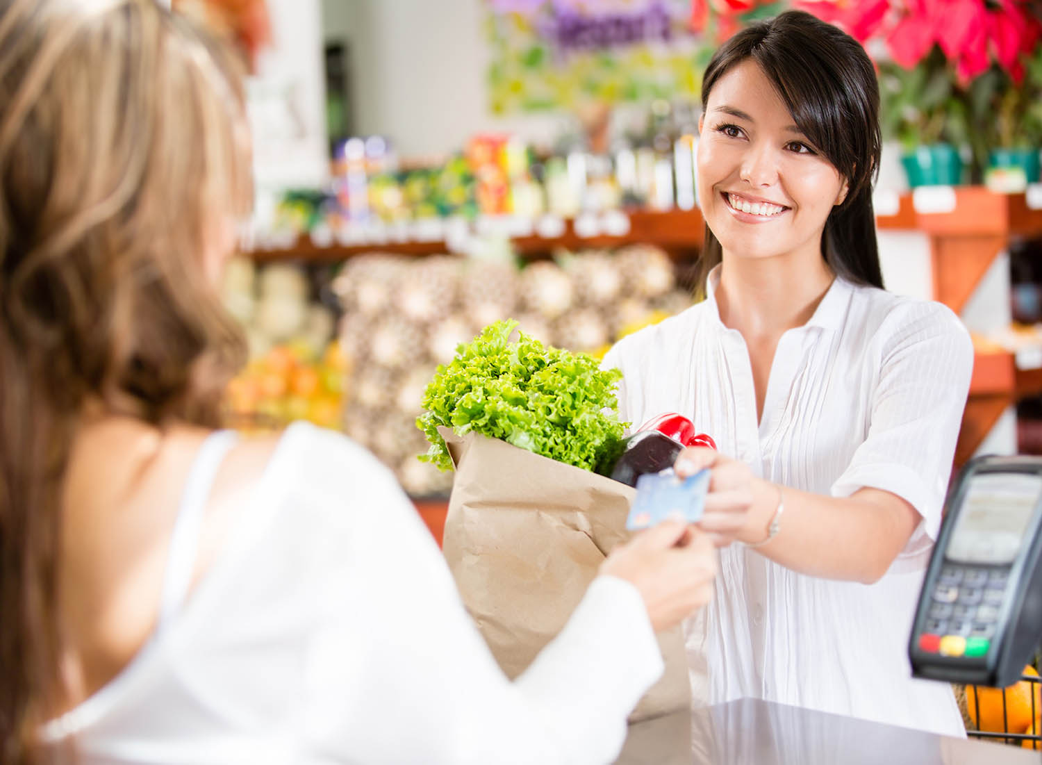image of woman shopping for groceries paying with credit card