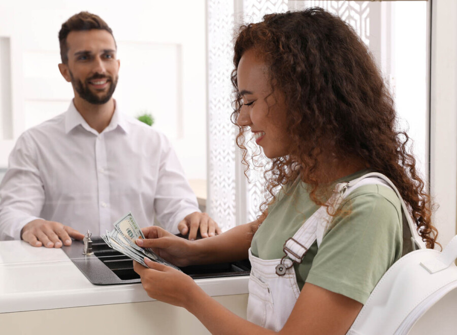 Credit Union Security image of female teller counting money back to a male customer