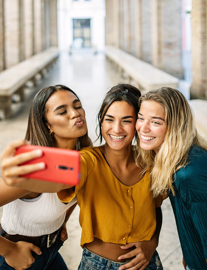 Three young females taking a selfie with cell phone