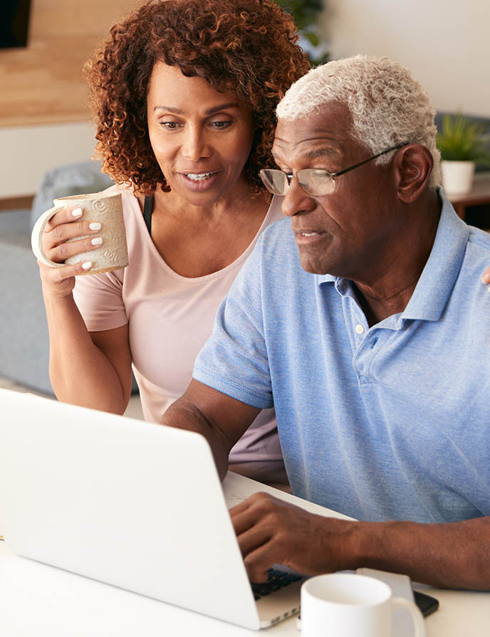 man and woman looking at something on laptop