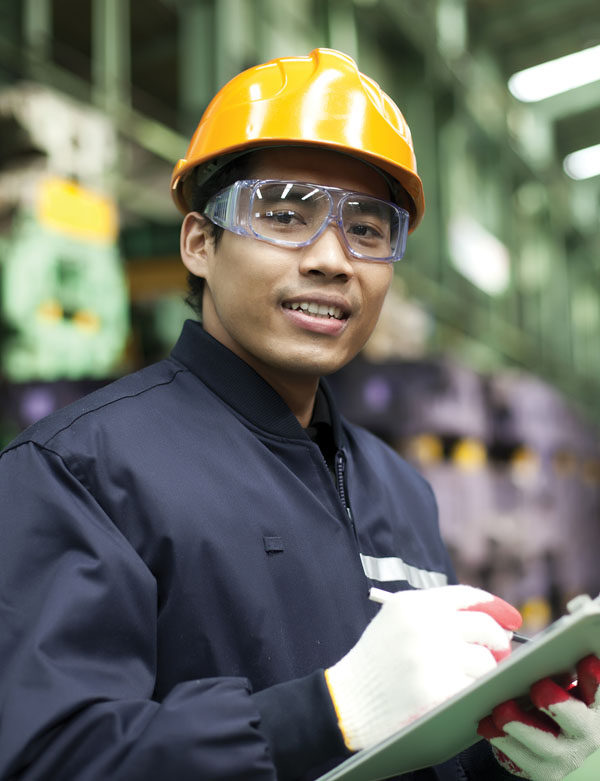 man in hard hat and protective glasses smiling