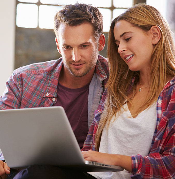 Refer a Friend Couple looking at laptop