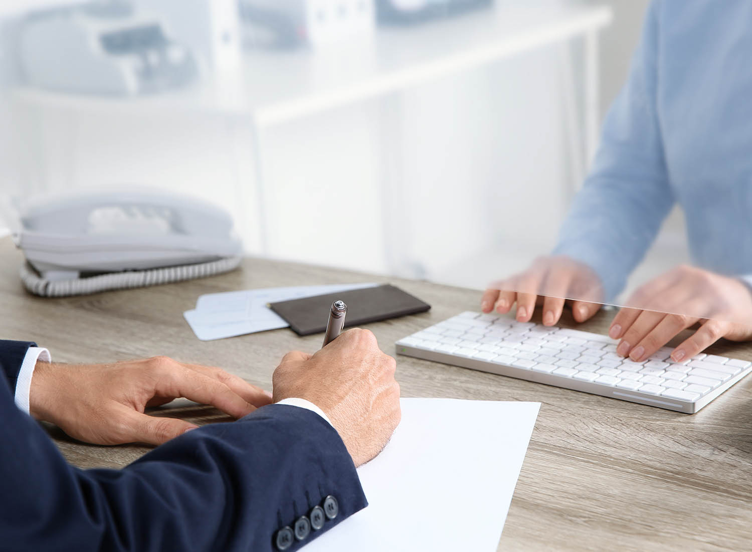 image of a person signing documents at a teller station