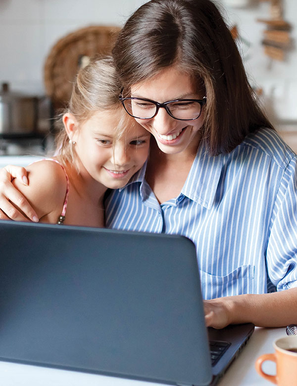 woman and daughter looking at laptop screen