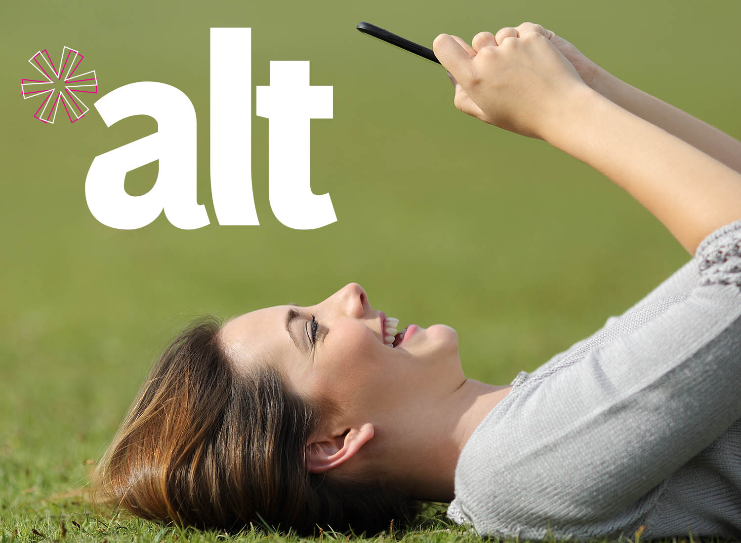 woman lying on back in grassy field on cell phone