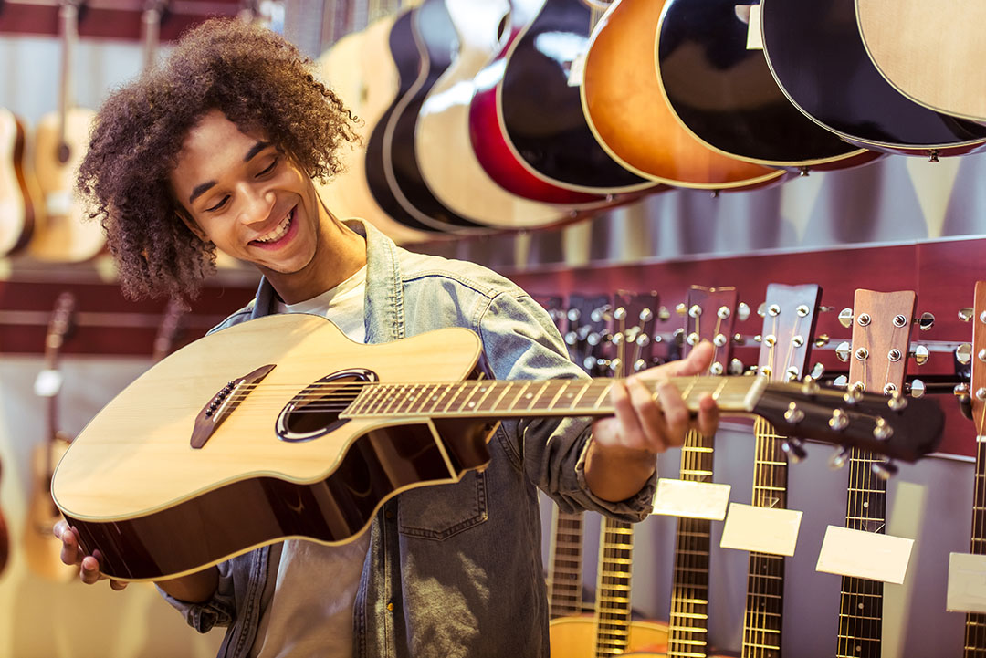 man looking at guitar