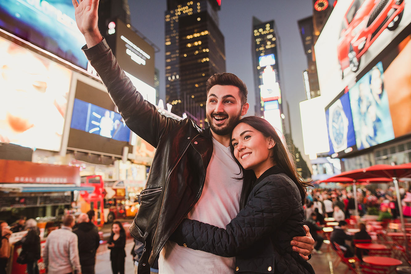 Beautiful multiracial couple in love on a date on Times Square in New York while travel across USA